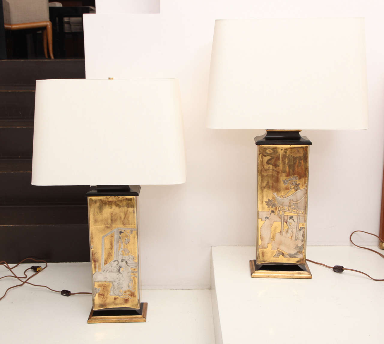 Near pair of gold églomisé table lamps with pagoda style painted wood bases and caps. Each features a different view of a chinoiserie scene.
American, circa 1940.