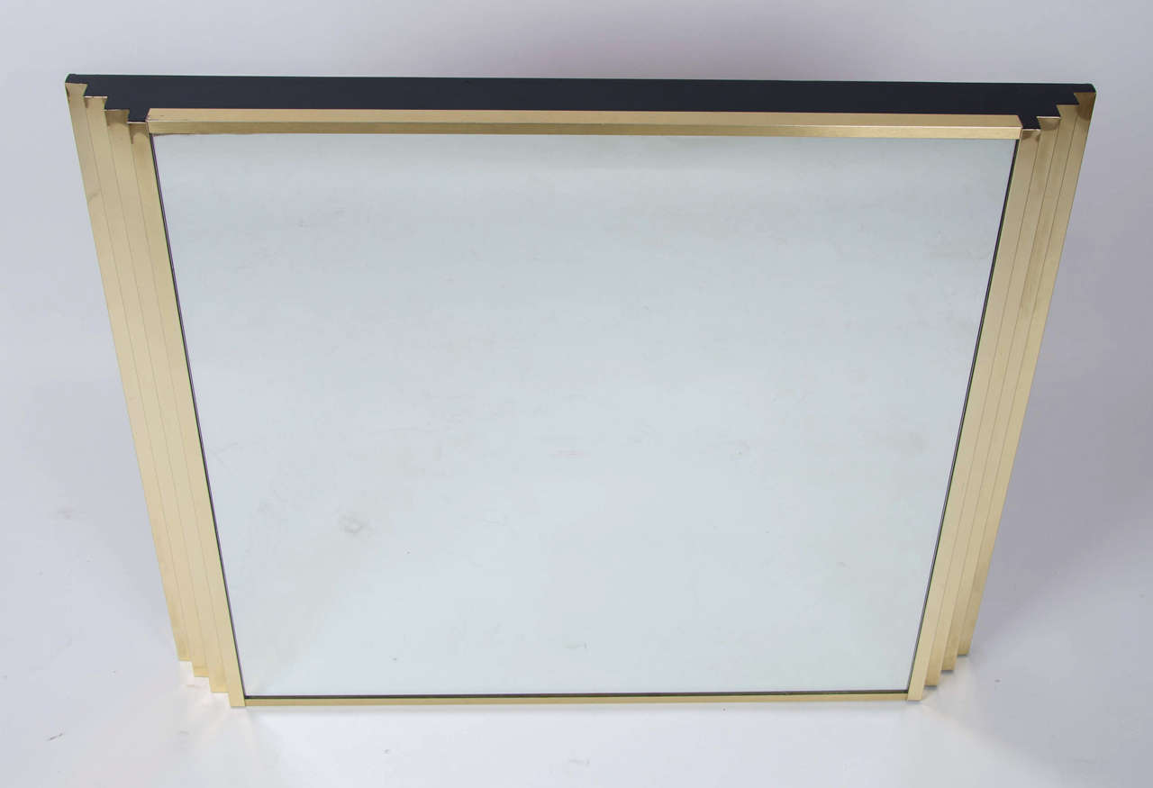 1970's italian rectangular mirror in a golded alluminium frame with descending steps on the sides and a flat black painted top and bottom.Matching console table available.