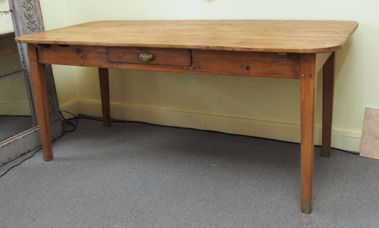 Rustic pine farm table, Italy c1910, having a single drawer with brass cup handle and 4 straight tapering legs. The naturally finished top glows from  years of waxing and buffing.