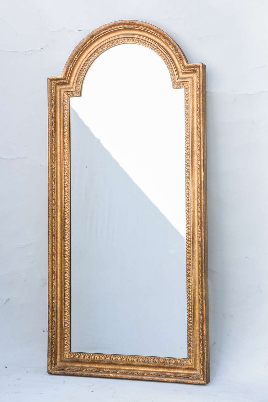 Pair of giltwood mirrors, having a rectangular form with arched pediment, each molded frame carved with gadrooning and rope details.