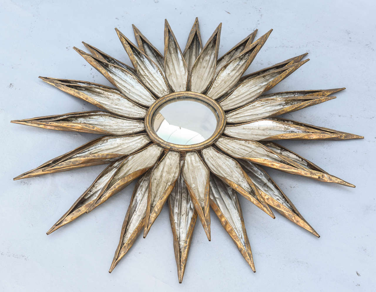Pair of sunburst mirrors, of tole with silver and gold gilded finish, each centered with a convex mirror, having two-tiers of metal 