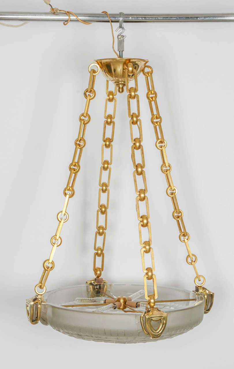 Large and important chandelier by Marius-Ernest Sabino.
The heavy glass round center bowl suspended by heavy brass chains (replaced) and brass canopy. Height adjustable. The brass parts can be silver or nickel-plated.