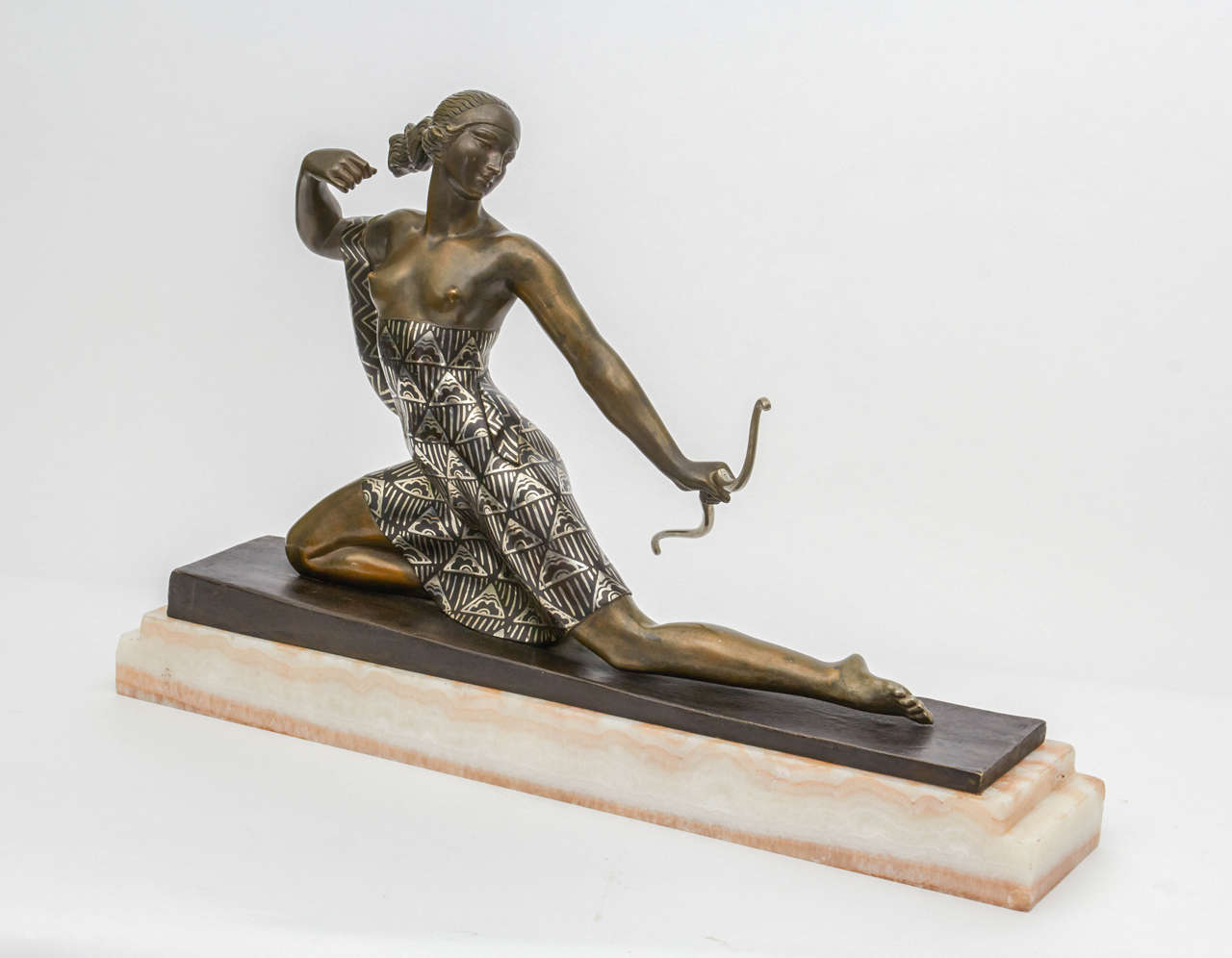 A French Art Deco archer figure, “Diana the Huntress” by Joseph Descomps (born J.E. Cormier, French, 1869-1950), from circa 1928. Patinated and enameled bronze, mounted on a white-yellow onyx base. Signed in the bronze.