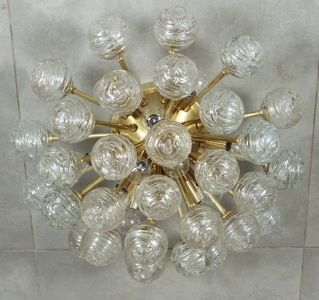 Giant Sputnik flush mount fixture by Doria Lighting Co.
This 1950s fixture has 31 Individual handblown swirl glass elements and 12 light sources to make this a truly stunning fixture when it is illuminated.
It is meant to be a flush mount, but