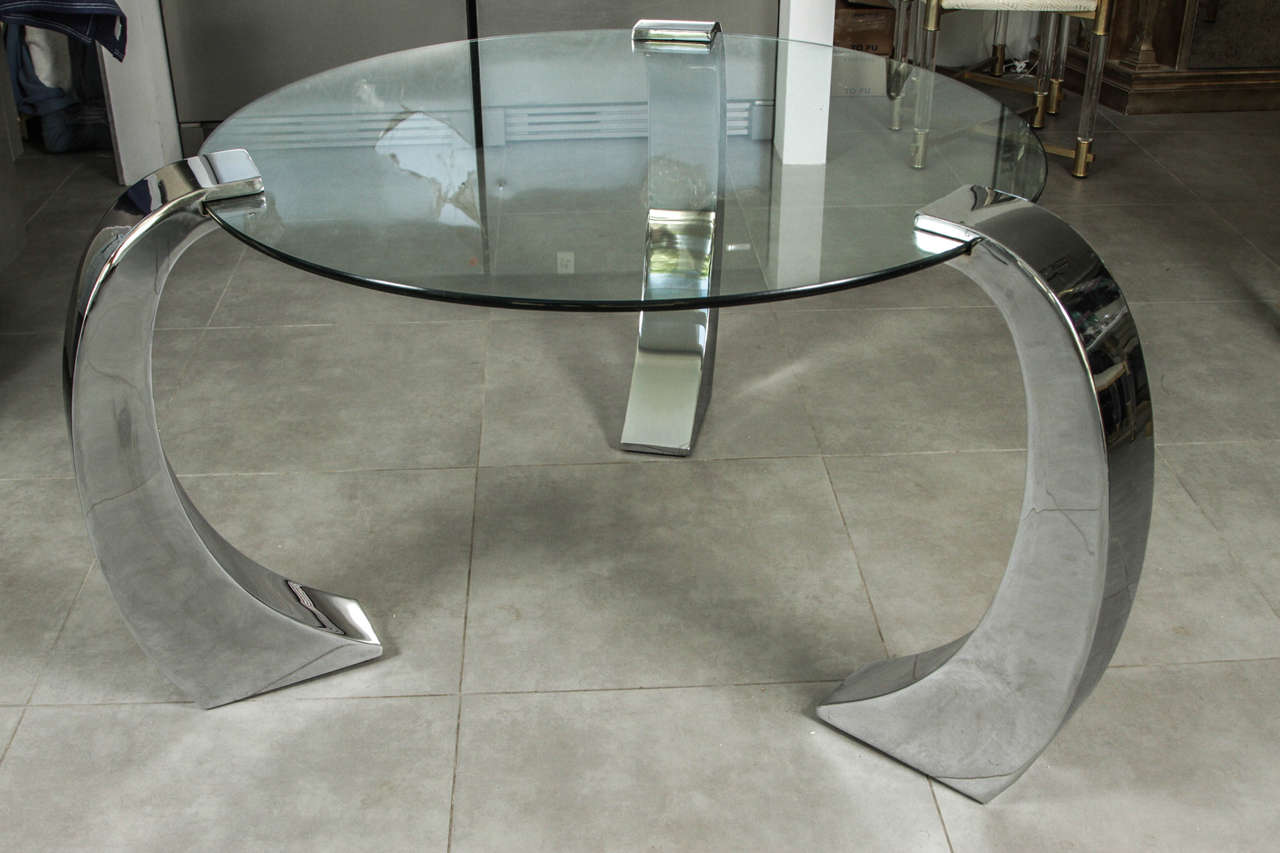 Circular entry center table of glass with three discreet chrome supports. The glass slides into slots in the bases. 
The glass top is 1/2