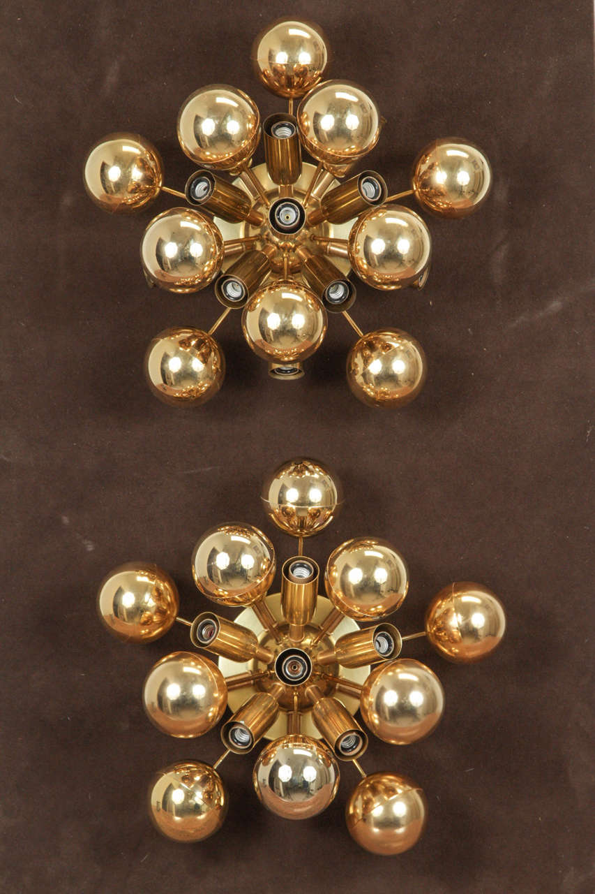 Wonderful pair of 1960s Sputnik sconces by Cosack.
The gold colored spheres have a nice patina and are accompanied
by eleven-light sources and are mounted on polished brass back plates.
The fixtures have been newly rewired for the US and take