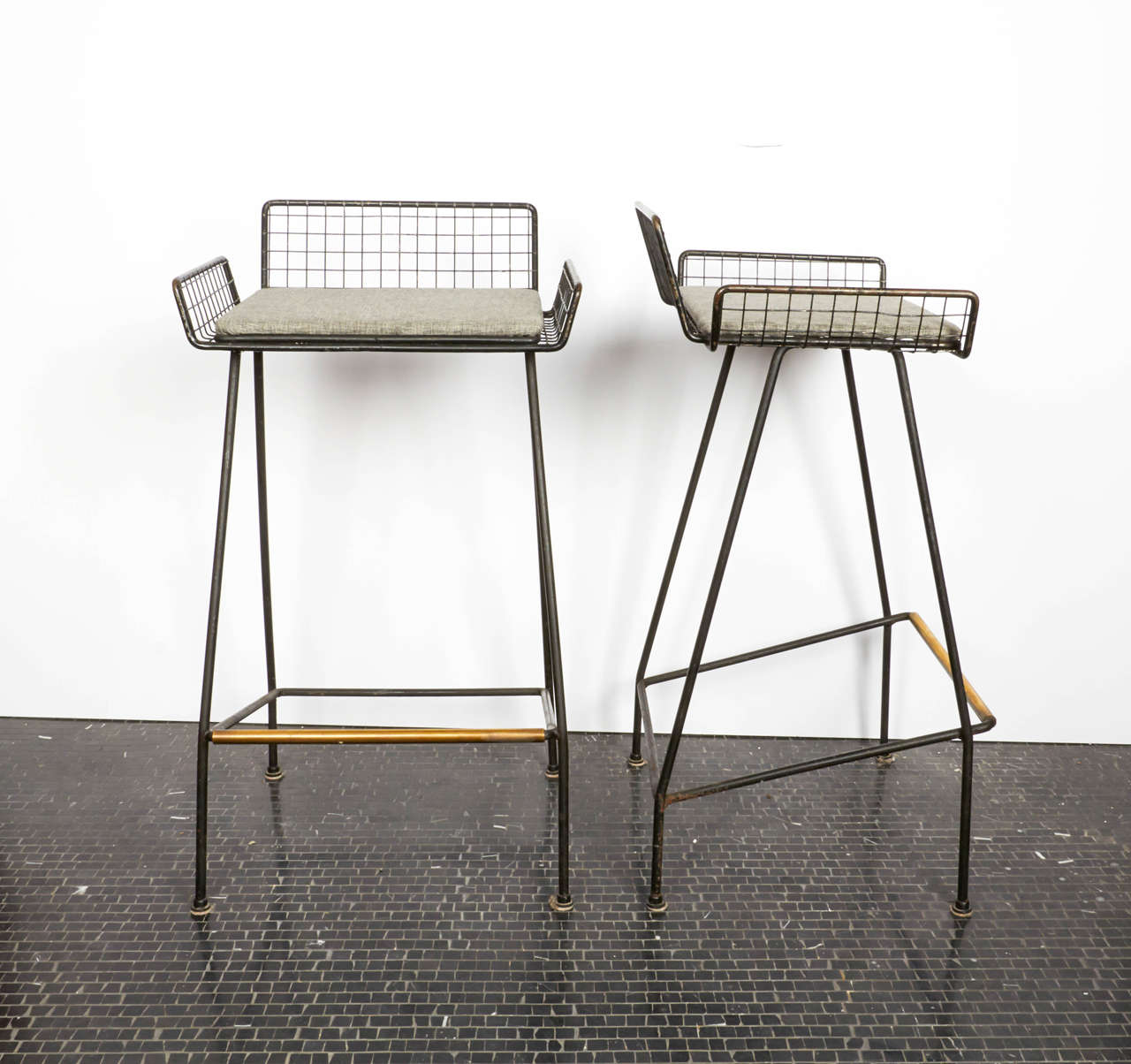 Pair of Tony Paul iron and brass bar stools, 1950s, American.