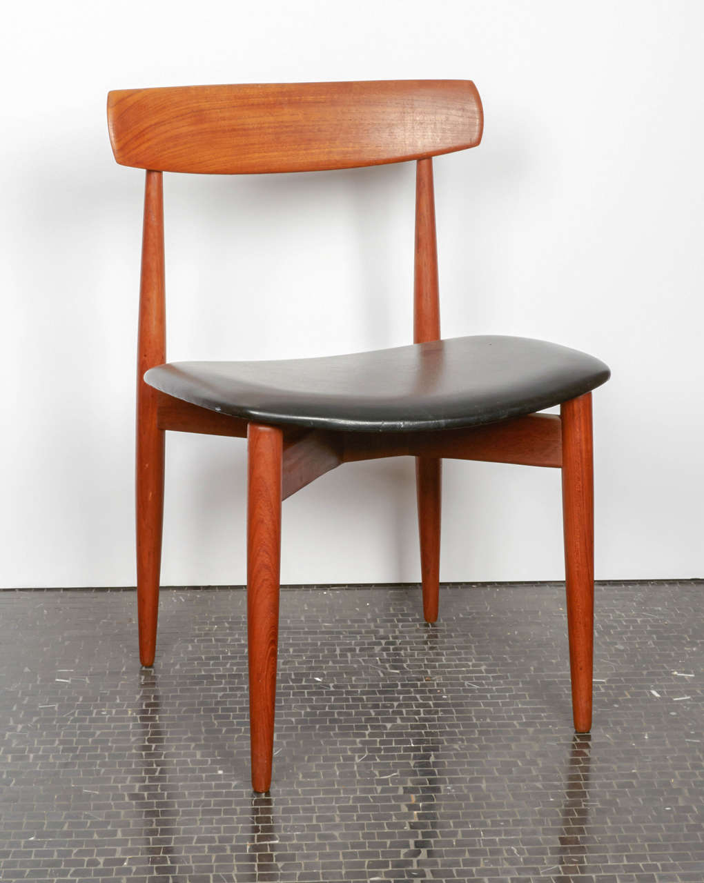 This set of four dining chairs, model 250, was designed by H. W. Klein in 1964 and produced by Bramin Furniture. Each chair is made from solid teak and upholstered in black leather.