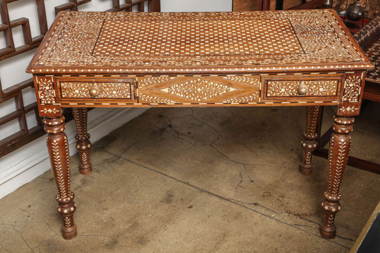 A wood desk with bone inlays, from India. Two drawers and turned legs. Classic inlay pattern.