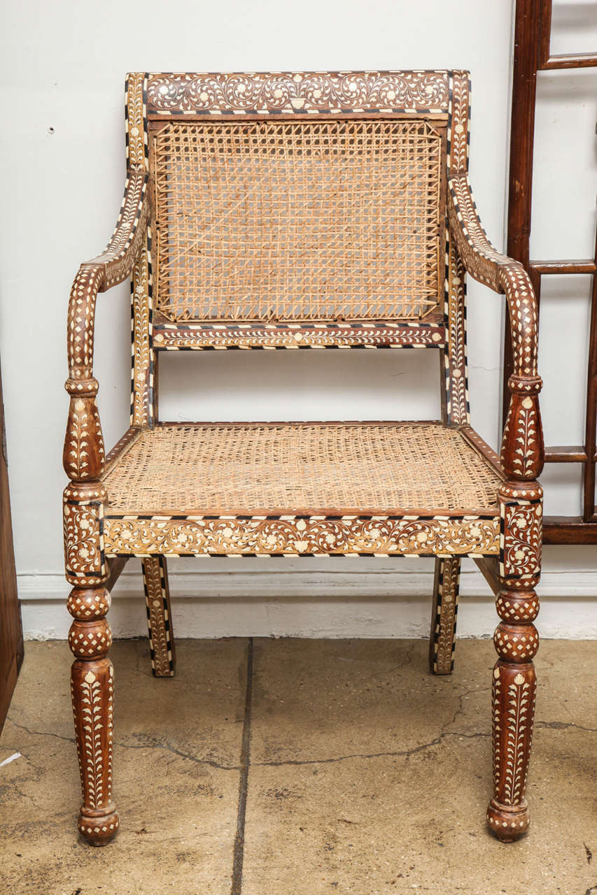 A bone inlaid armchair from India. Square back. Cane seat and back. Classic Indian inlay pattern throughout.
