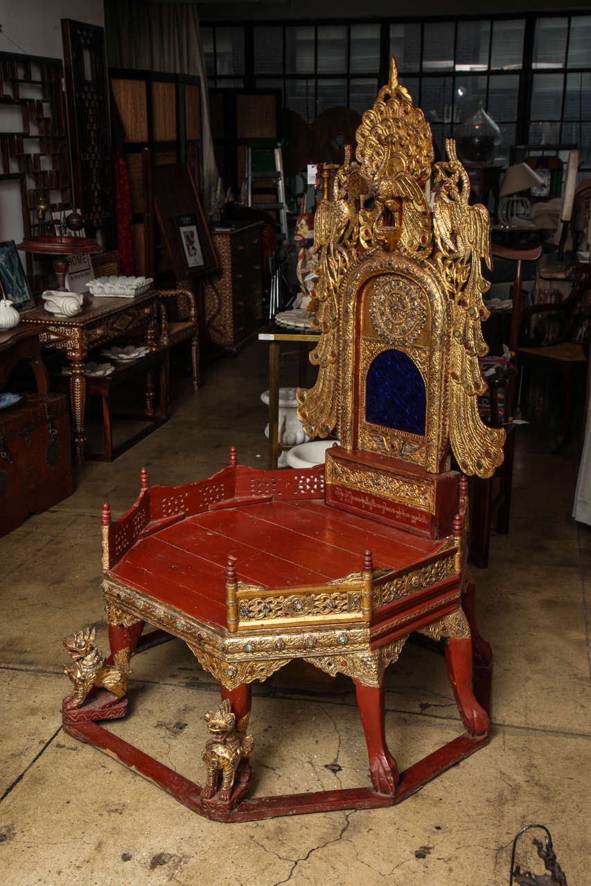 A Burmese Monk's bench, ornately carved back, legs and borders in red and gold and stone inlays. 100 years old.