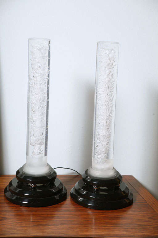 The Lucite cylinder above a black Lucite base.