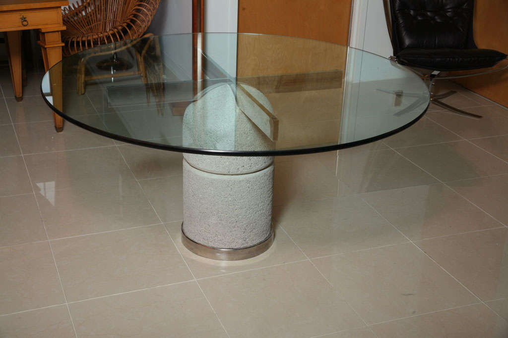 The glass top over a chrome x stretcher sunk into a concrete case with a chrome plinth- manufactured by Sapporiti.