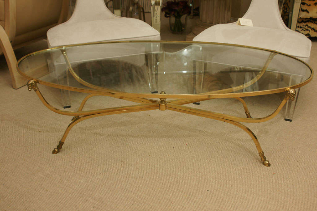 Brass oval rams head coffee table with x-stretcher and hoof feet