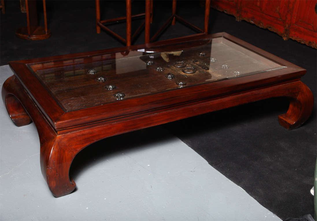A 19th century unique antique door with iron fittings made into a coffee table. This unique elm coffee table was made from an unique Chinese 19th century door with hand-forged iron fittings. The rectangular table features a typical modern Chinese