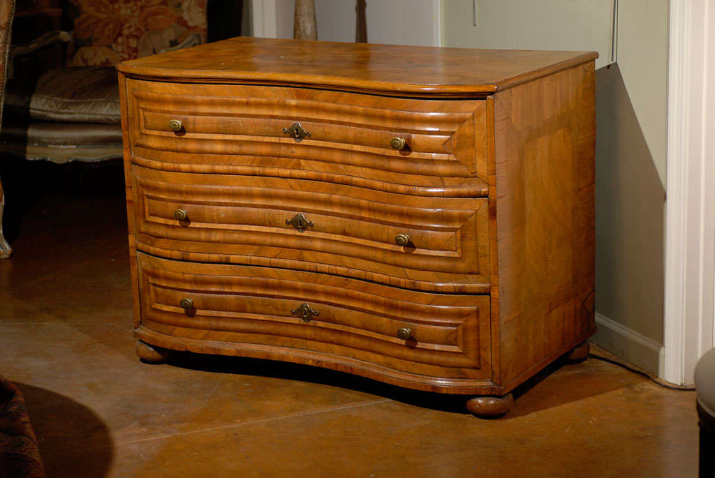 18th century walnut serpentine German commode, the top surmounting three conforming long drawers and raised on ball feet. 