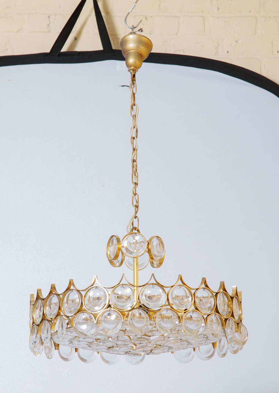 Gold plated Chandelier by Palwa.   
Crystals framed by gilded brass rings. 
Original good condition.
The fixture holds nine bulbs (40W).