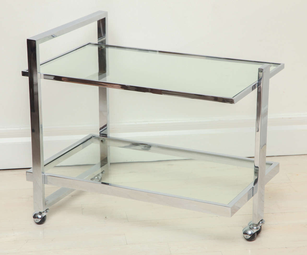 Chrome and glass two-tiered bar cart on ball casters