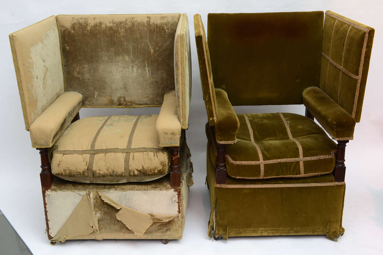 Rare and unusual pair of fireplace chairs with adjustable arms. When the arms are in the up position, they contain the warmth of the fireplace. They can be adjusted to several positions for varying comfort levels.