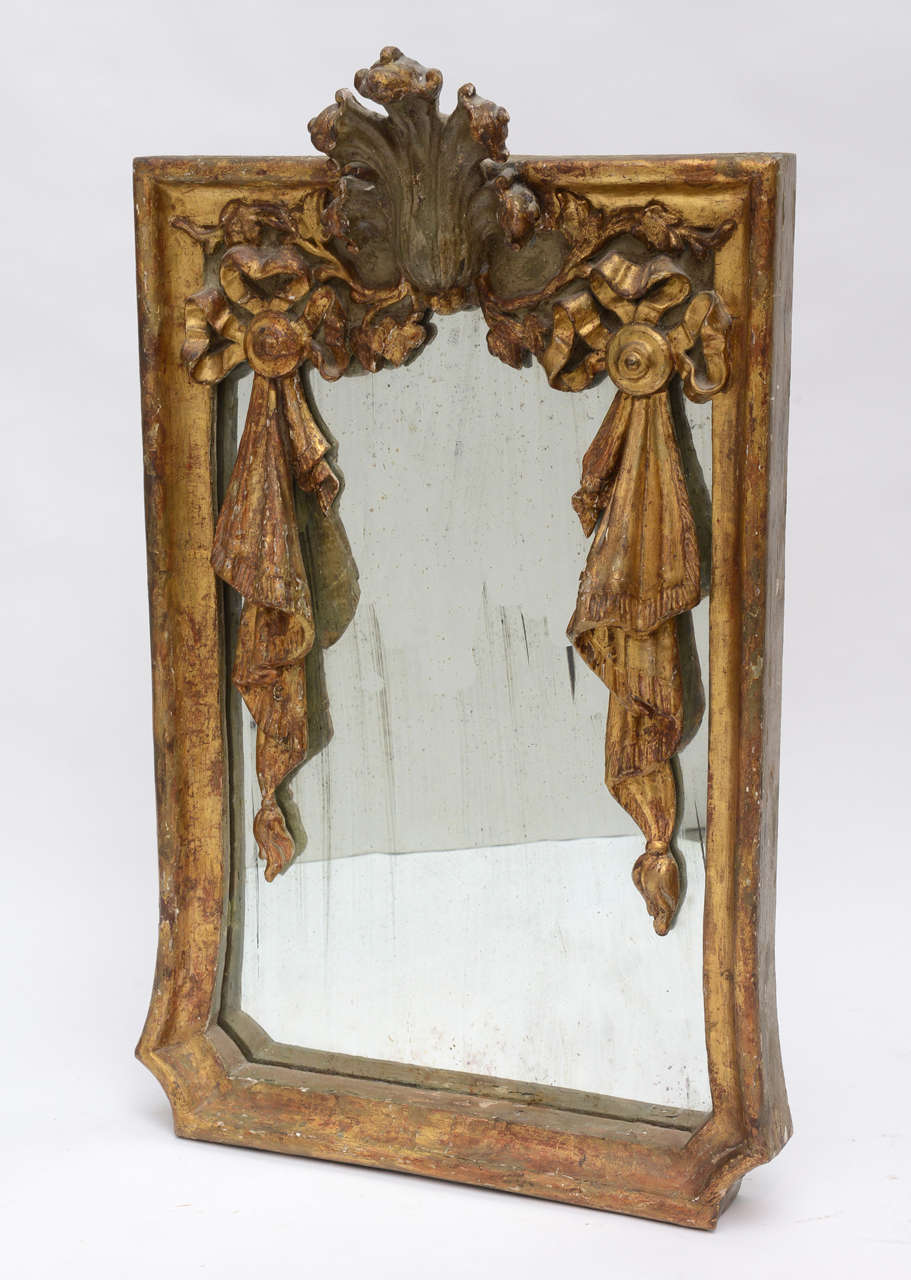 Heavily carved French mirror with ribbon and swag motif.