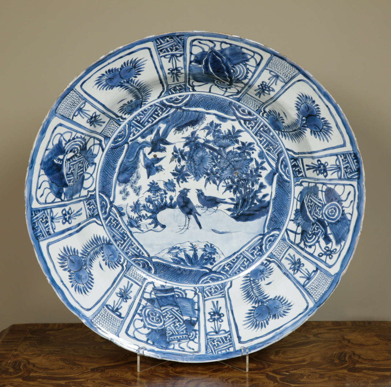 A large Chinese blue and white kraak charger, Wanli (1573-1619), decorated in the centre with a pair of black birds and flowers issuing from rockwork. The panelled border decorated with flowers and precious objects. Good solid blue glaze. Condition: