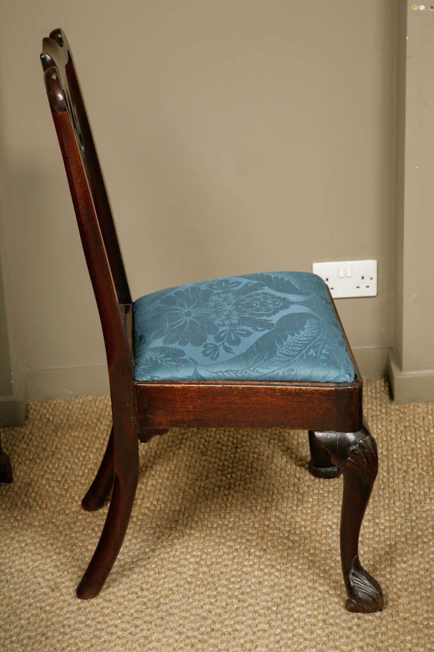An Irish mid 18th century mahogany chair with yoke cresting top above a pierced vase-form splat, drop-in seat, on shell-carved cabriole legs terminating in inward folding scroll feet.  Good original patina, slight discolouration between the various