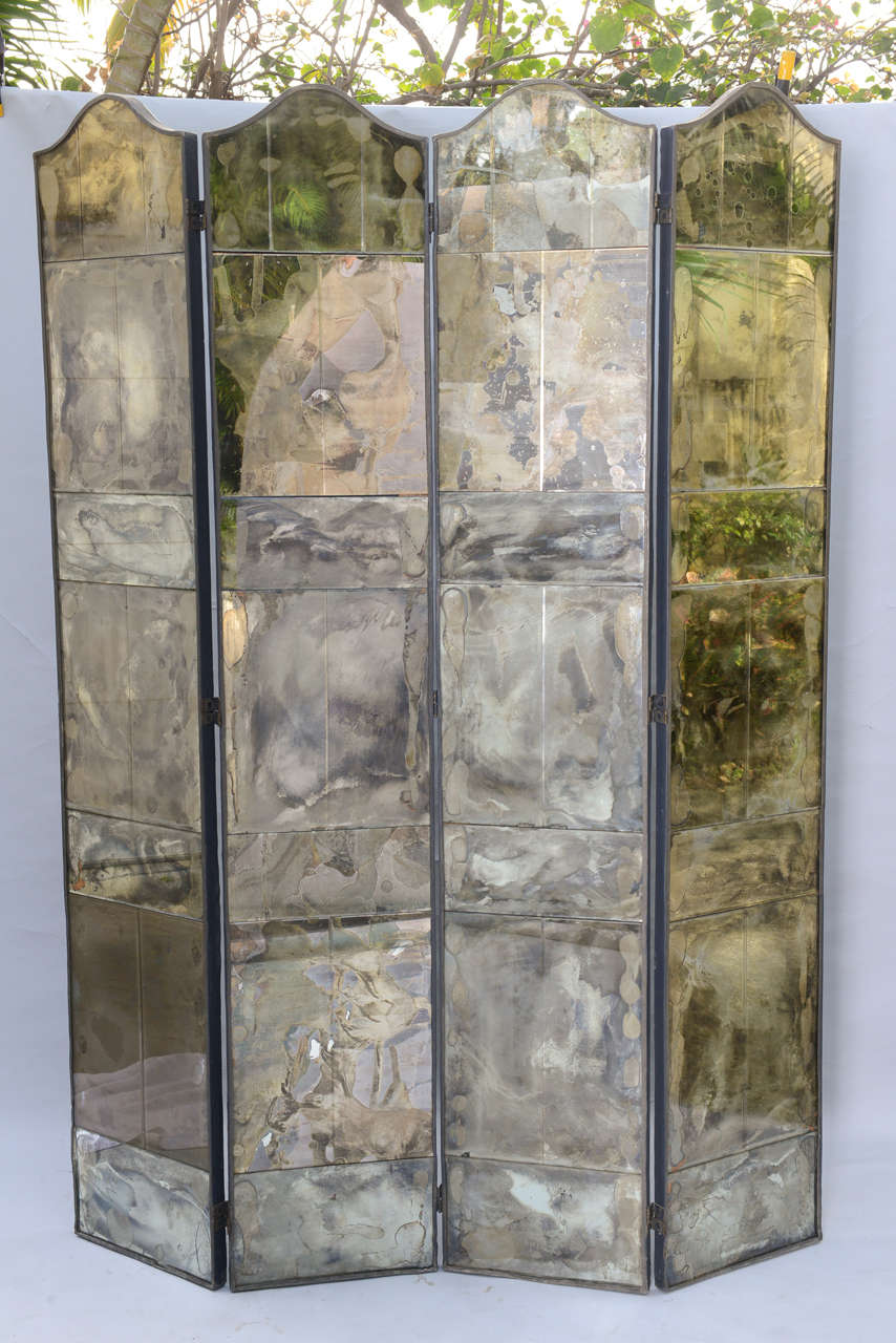 Room divider screen, having four folding panels, of smoked and distressed mirrored tiles, arched top. Each measures approximately 14