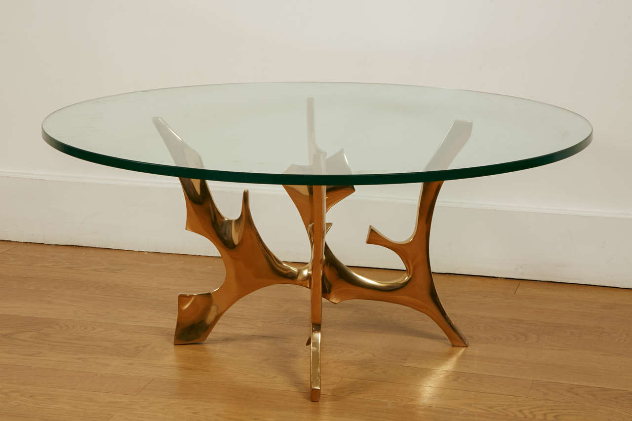 Circular coffee table by Fred BROUARD, 1970's.
Gilt polished bronze coffee table, with a circular glass top.
Signed and numbered 11 / 25. 
Base diam.54 cm.

Fred Brouard (1944-1999), met Alicia Penalba and Henri Georges Adam then he worked with