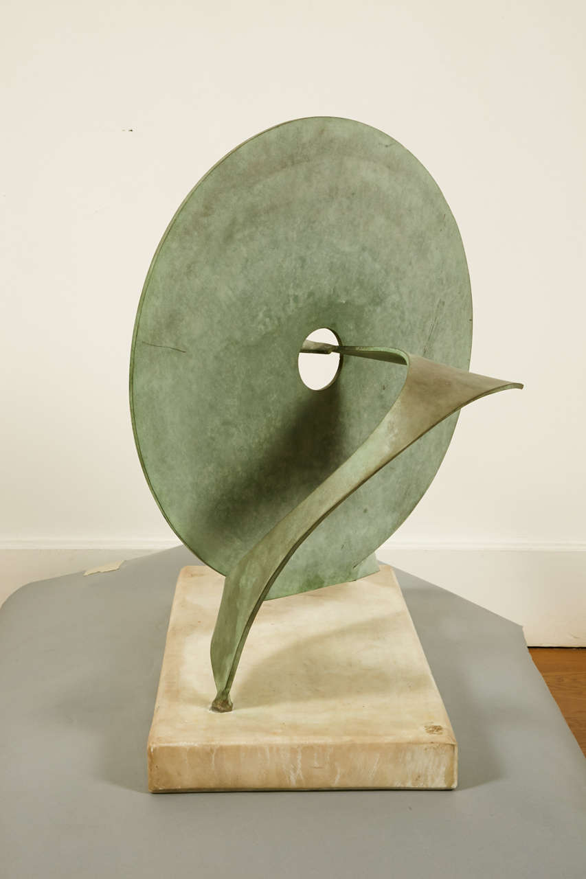 Disc sculpture by Guy Lartigue (1927-).<br />
Antique green patinated bronze, rectangular white marble base.<br />
Unique piece.<br />
<br />
Guy Lartigue is a sculptor since the 1950s. He exhibited in several official Salons, created fountains and