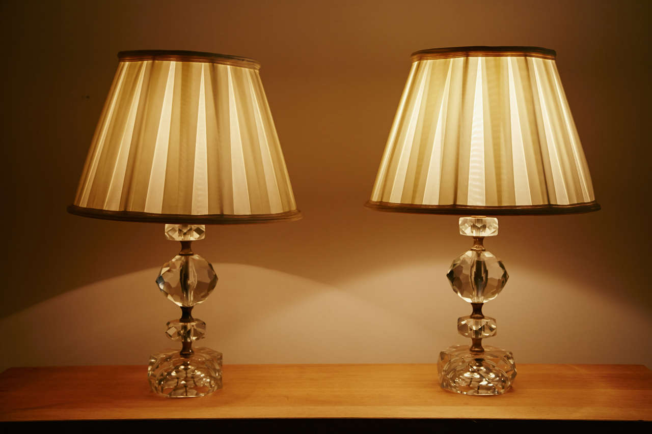 Refined pair of cut-glass table lamps, France, 1950s.
Gilt brass structure and rings. Cream white silk shade with 