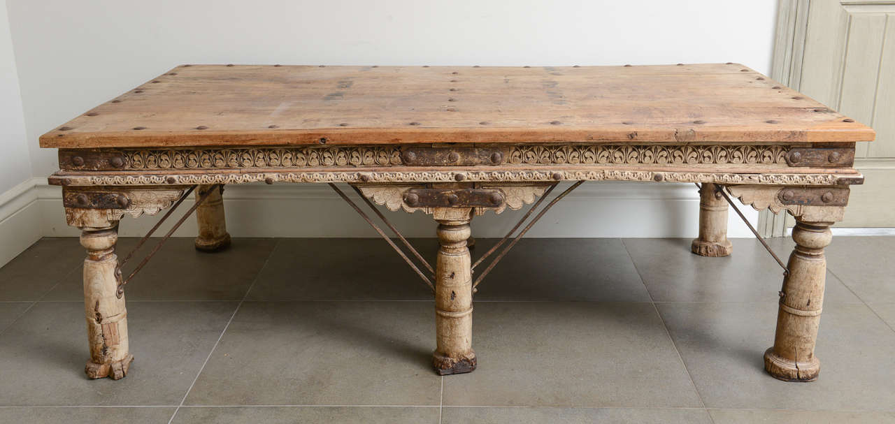 Fantastic early 20th century large hand carved and ornate Indian bed/ coffee table, with six legs reinforced with iron stretchers and the top of the table is assembled with iron rivets. The table is in a good antique condition with the wear adding
