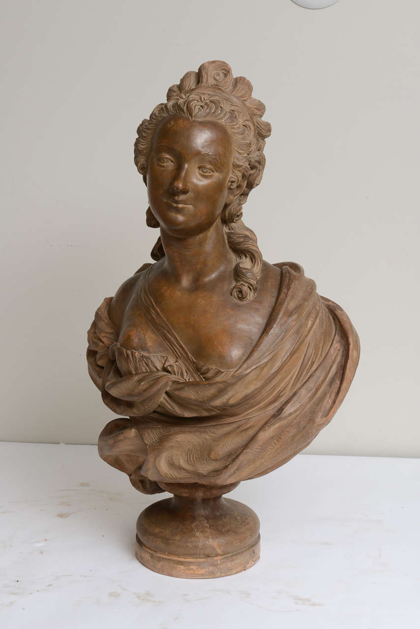 Bust of a lady depicted wearing robes over her shoulders, raised on a pedestal base made of Terra cotta in France in 19th century.