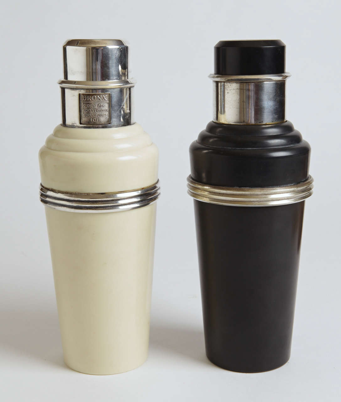 Classic pair 1930's English shakers.
THIRD VERSION AVAILABLE in mixed Black & White (not pictured).

Two Pictured Versions:

(1)  Original white phenolic body, with silver plate trim ring, cap, spout, strainer and revolving neck recipe dial. 