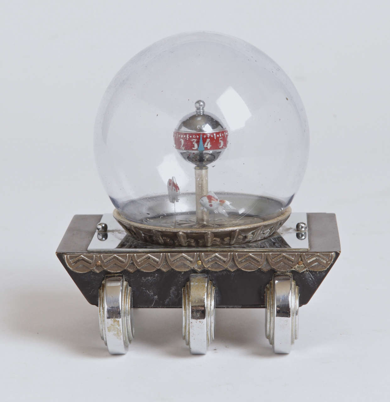Very cool early 30's design, with a revolving enameled chrome ball inside a removable glass dome indicating hours and minutes.  One rotating fish marks the seconds, while the second fish oscillates as part of the movement.  Nice deco trim frieze and