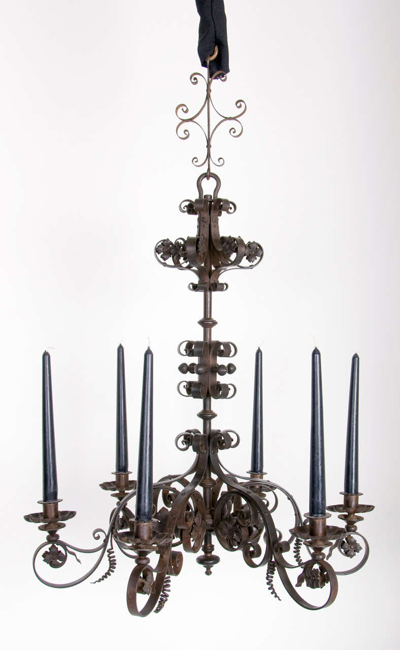 A unusual forged iron black patinated decorative 6 light candle chandelier in a 