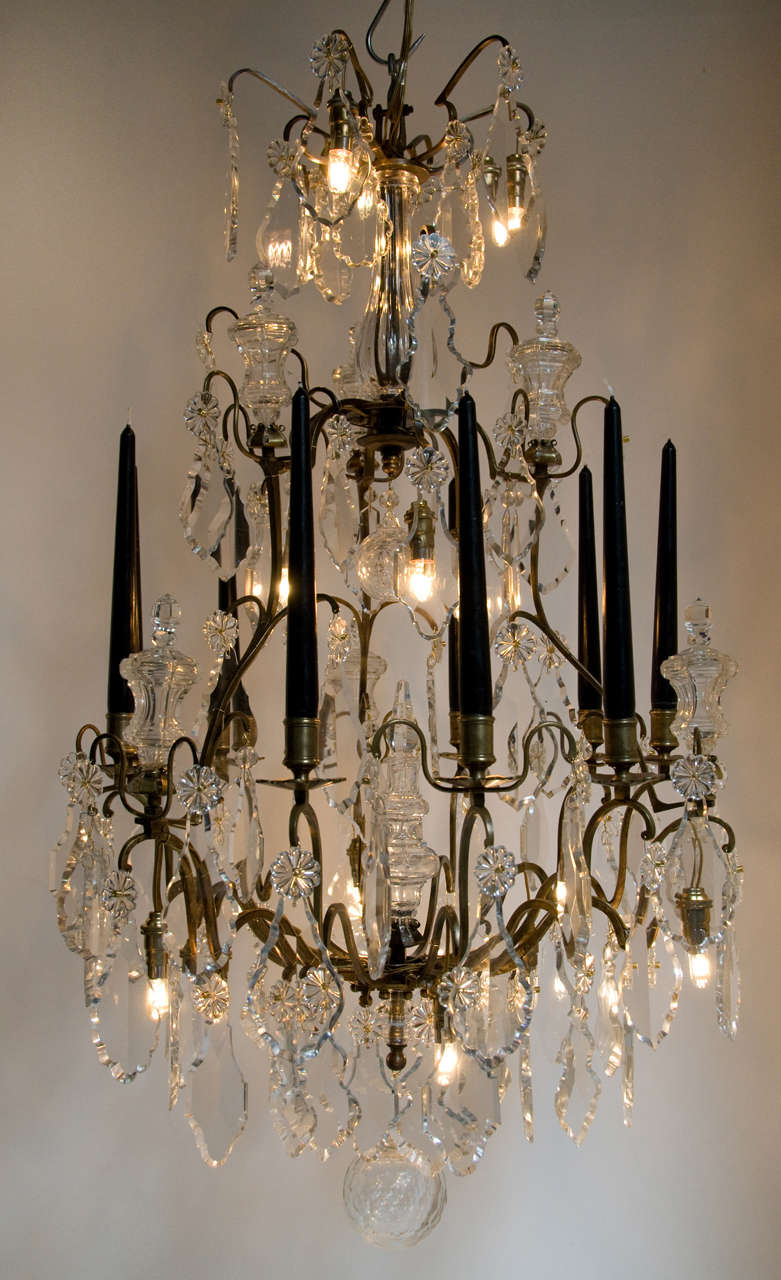 A Louis XV style bronze and crystal nine branches chandelier, last quarter of the 19th century<br />
An open cage frame issuing nine S-scrolled branches with floral shaped drip-pans and hung with cut crystal pendants in various sizes and shapes. On