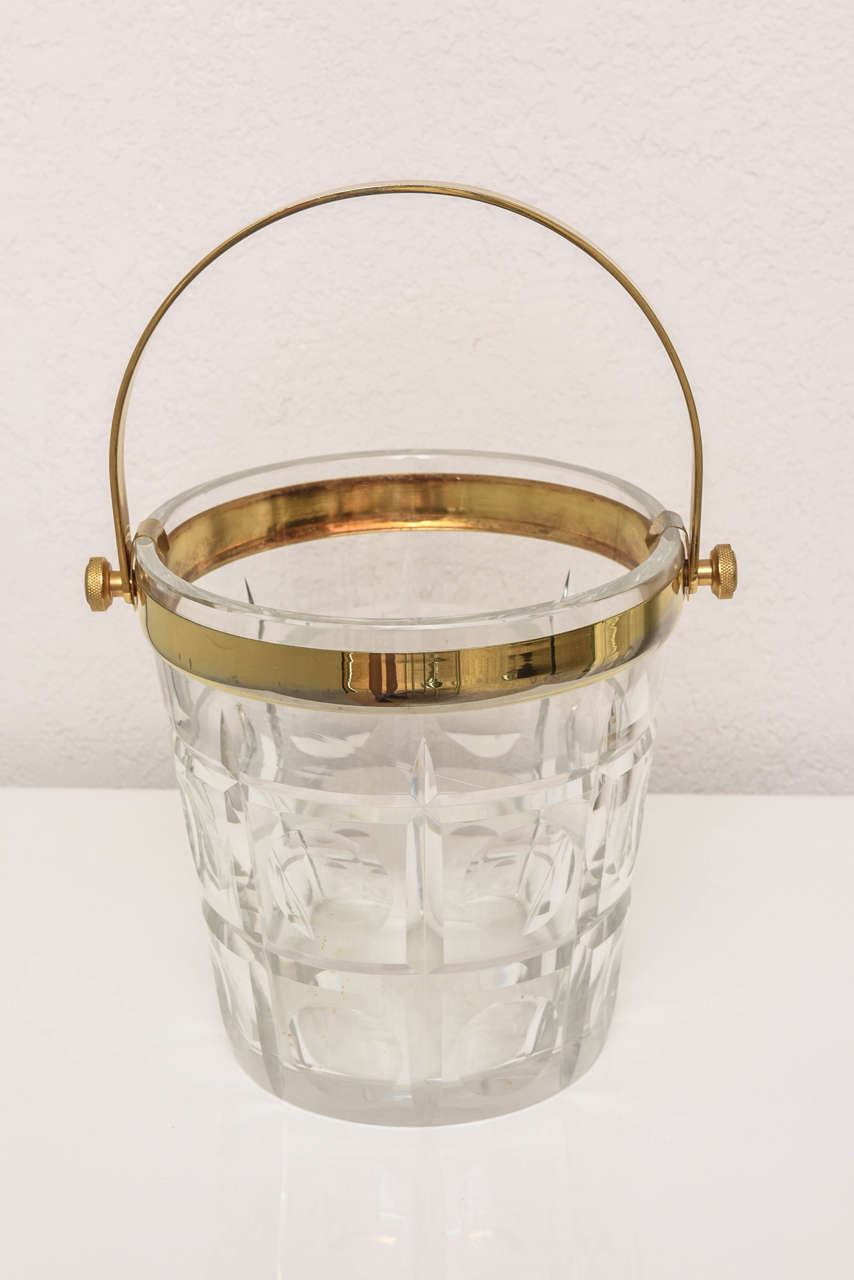 This stylish and chic cut crystal and brass ice bucket was acquired from a Palm Beach estate.

Note:  Dimensions with the handle up as pictured is 13.25