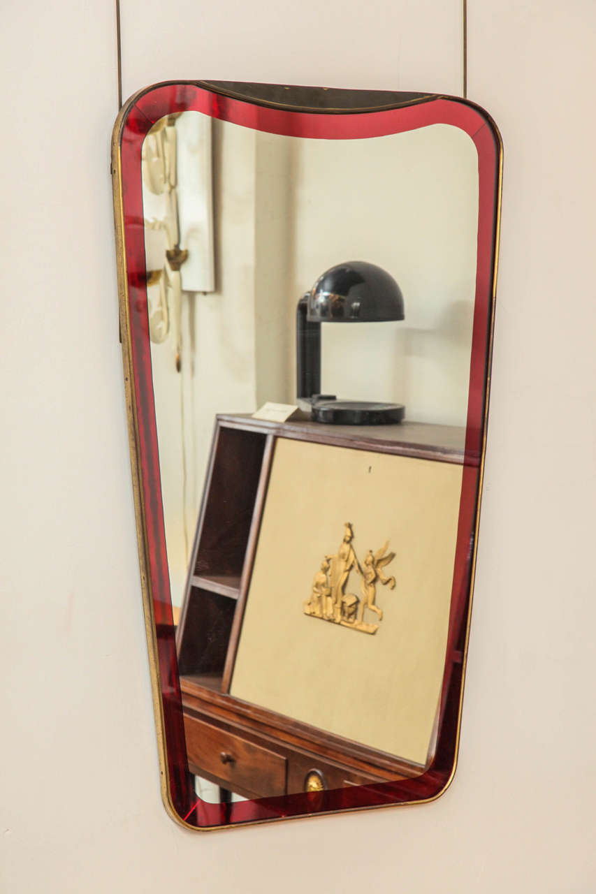 Stunning Cristal Arte mirror made in Italy 1950, superimposed red mirror border in a handmade brass frame, unusual model, great quality.
 