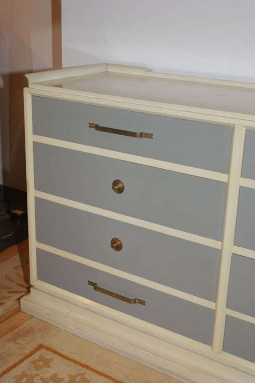 Tommi Parzinger (1903-1981) Chest of twelve drawers in ivory and dove grey lacquer, with alternating pulls and lipped top. Organizing dividers in most drawers. American, c. 1950