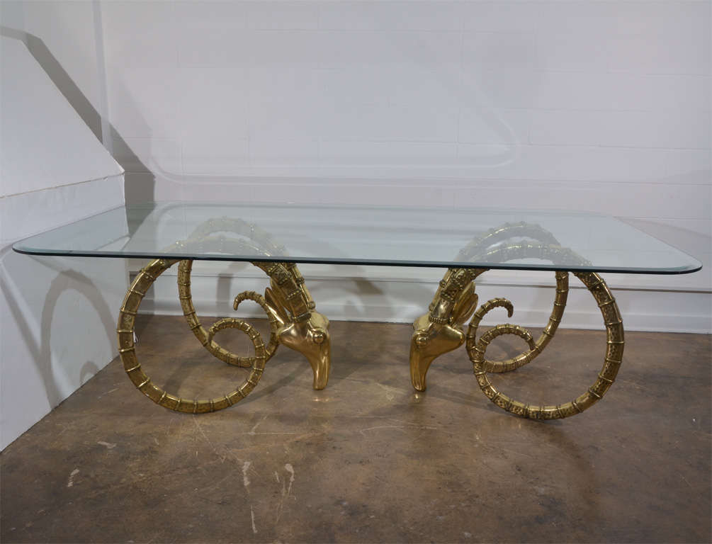 Iconic polished brass rams head dining table with glass top. Glass measures 52 x 96 x 30.5 and has curved corners and 1.5 inch beveled edge and is 1.5 inch thick.