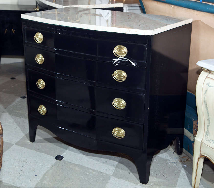 Pair of ebonized marble top bow front chests of drawers, 20th century, the white marble over a conforming case fitted with four graduating drawers, raised on splayed feet. Custom quality w oak interiors and drawer slides of oak. Custom Quality.