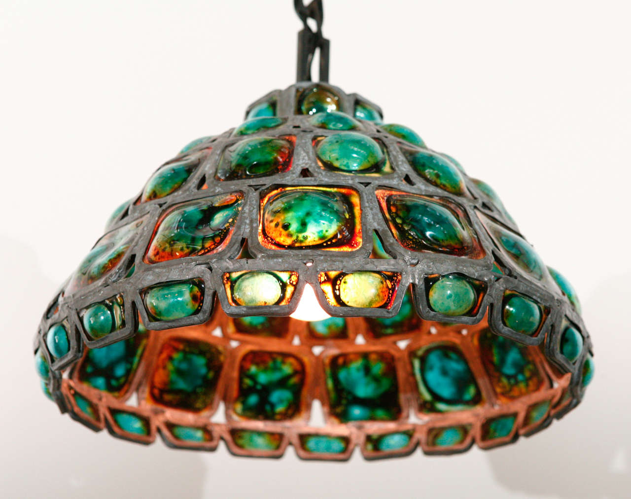 Hand blown turquoise art glass pendant with metal frame.
