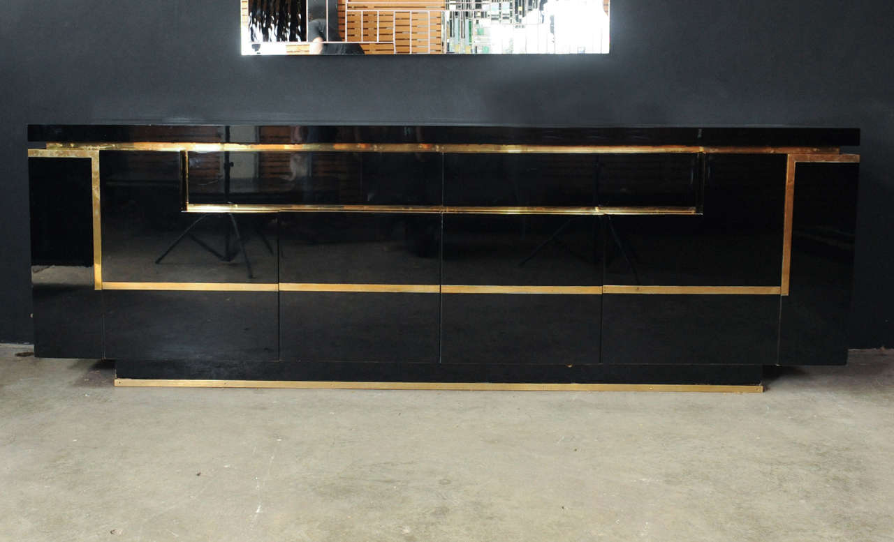 A truly spectacular and very rare sideboard by French designer Jean-Claude Mahey. The piece is carried out in a high gloss mirroring black piano lacquer and copper detailed lines and has drawers, shelves and 2 cocktail compartments on the sides that