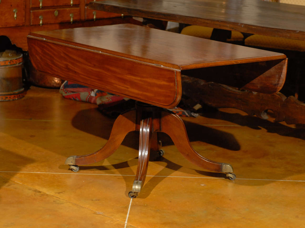 Georgian mahogany drop-leaf table with shaped legs terminating in brass feet and castors, England, circa 1790.

52