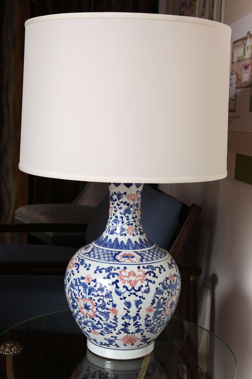 This exquisite bowl-shaped porcelain table lamp has a decorated base with a cream-colored cylinder shade that finishes off its clean look. The shade has a pearly paper inside and a contemporary silk outside, and it is 17.13