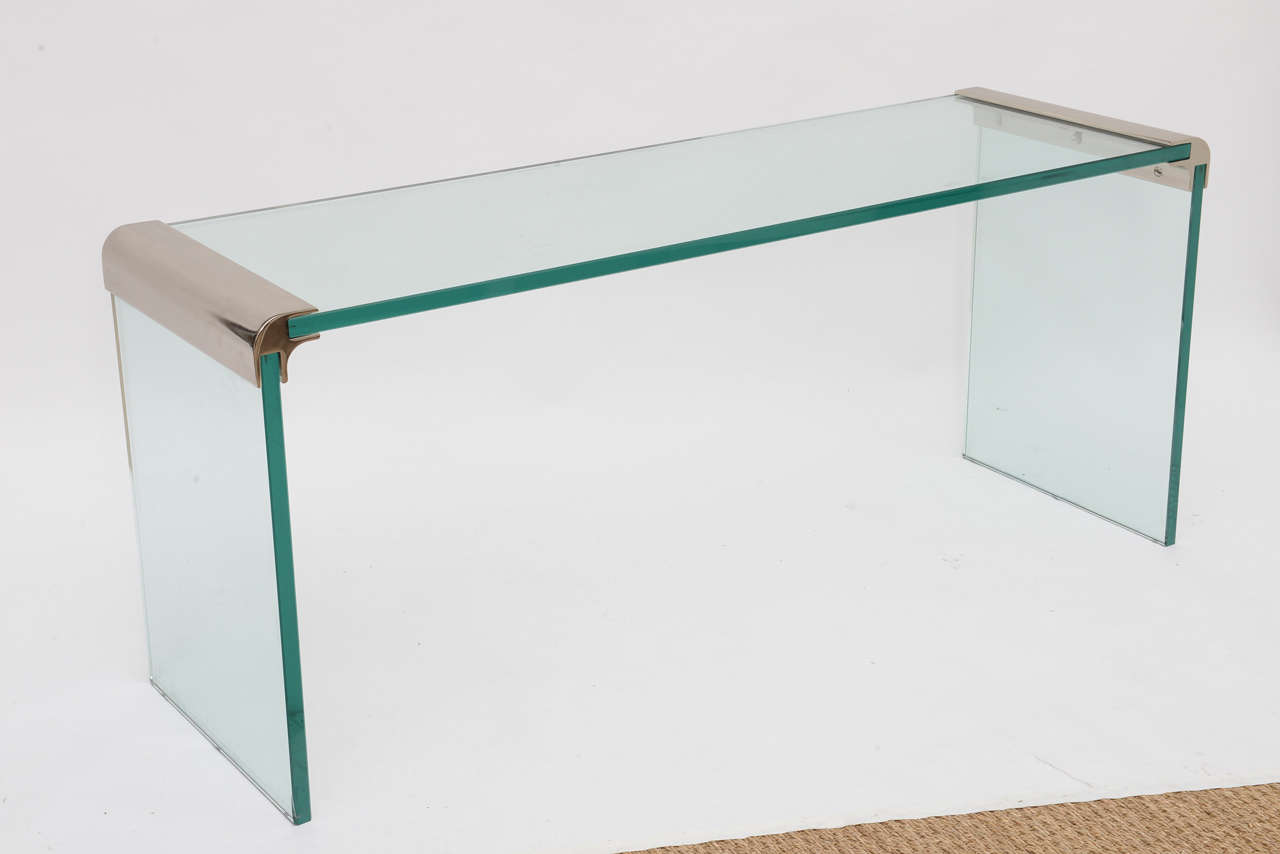 Pace glass and polished steel occasional table with waterfall corners brackets. At no additional cost to you we can custom size this table to cocktail table size. At a nominal cost we can customize this table to a taller height of your choice--the