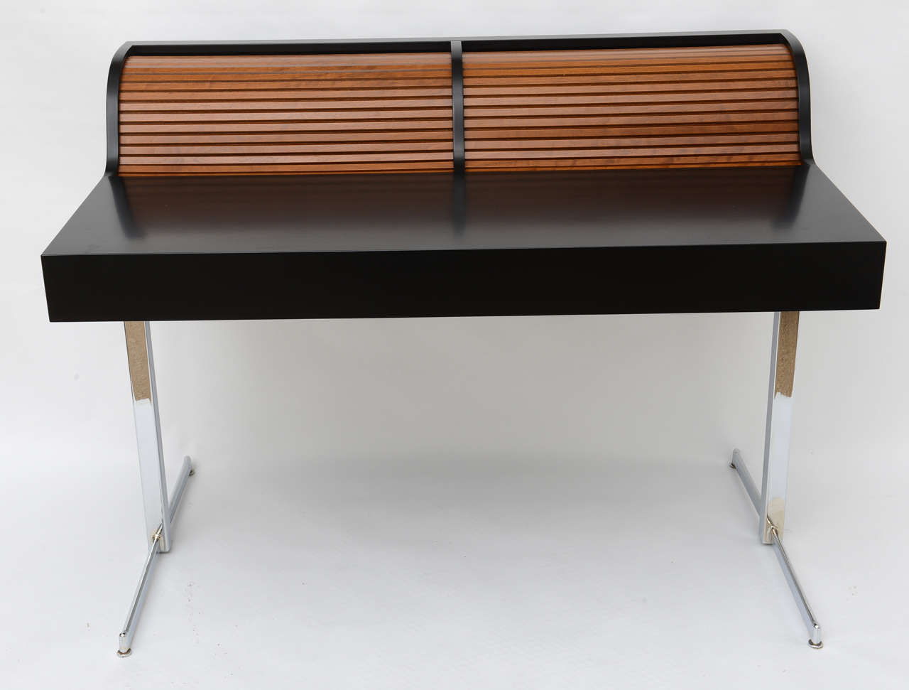 Fantastic black laminate desk with natural channeled roll tops, side by side, and nickel over steel legs. This iconic design began with Herman Miller and this desk is a family member from the period.
Measures 28.5