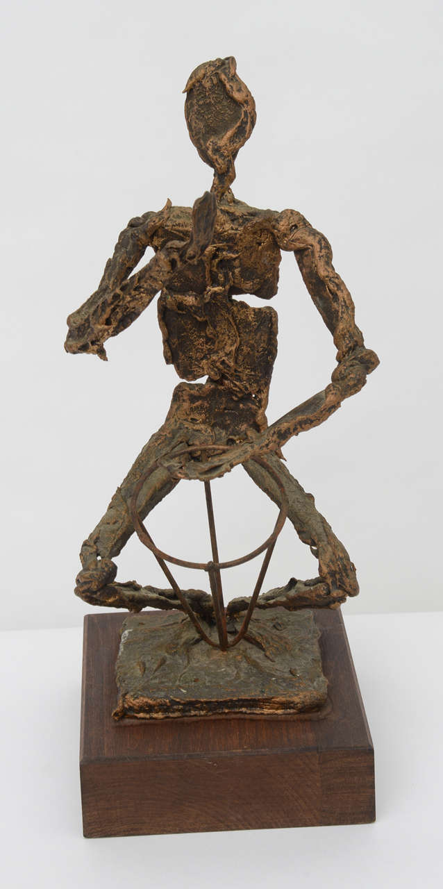 Hand formed Brutalist metal sculpture of a drummer fashioned of scorched and molten metal with a gold wash. Mounted on thick wood block. Great midcentury tabletop sculpture.