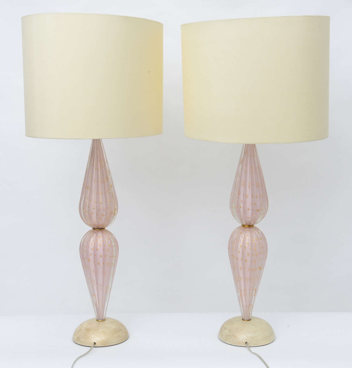 Stunning pair of handblown ribbed Murano glass lamps in a rarely found beautiful shade of Venetian pink with gold bubble inclusions and a lot of gold flecking designed by Alfredo Barbini. The lamps are designed using two opposing handblown teardrop