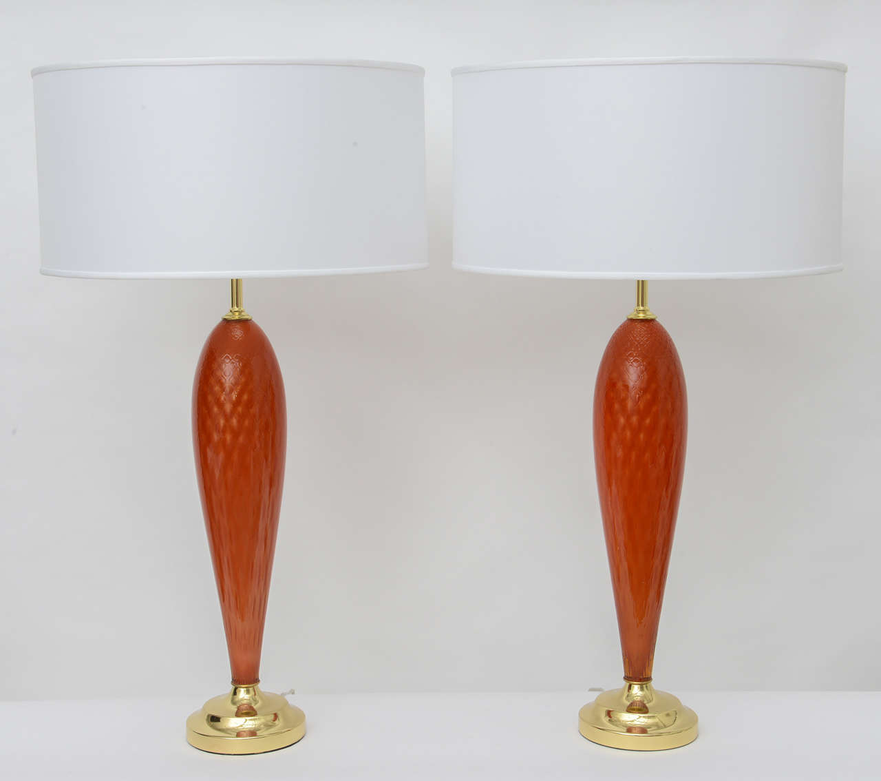 Pair of hand blown Murano glass lamps in rich textured orange. Newly rewired and appointed with brass bases and sockets. Sold as pair.  Shades sold separately.
